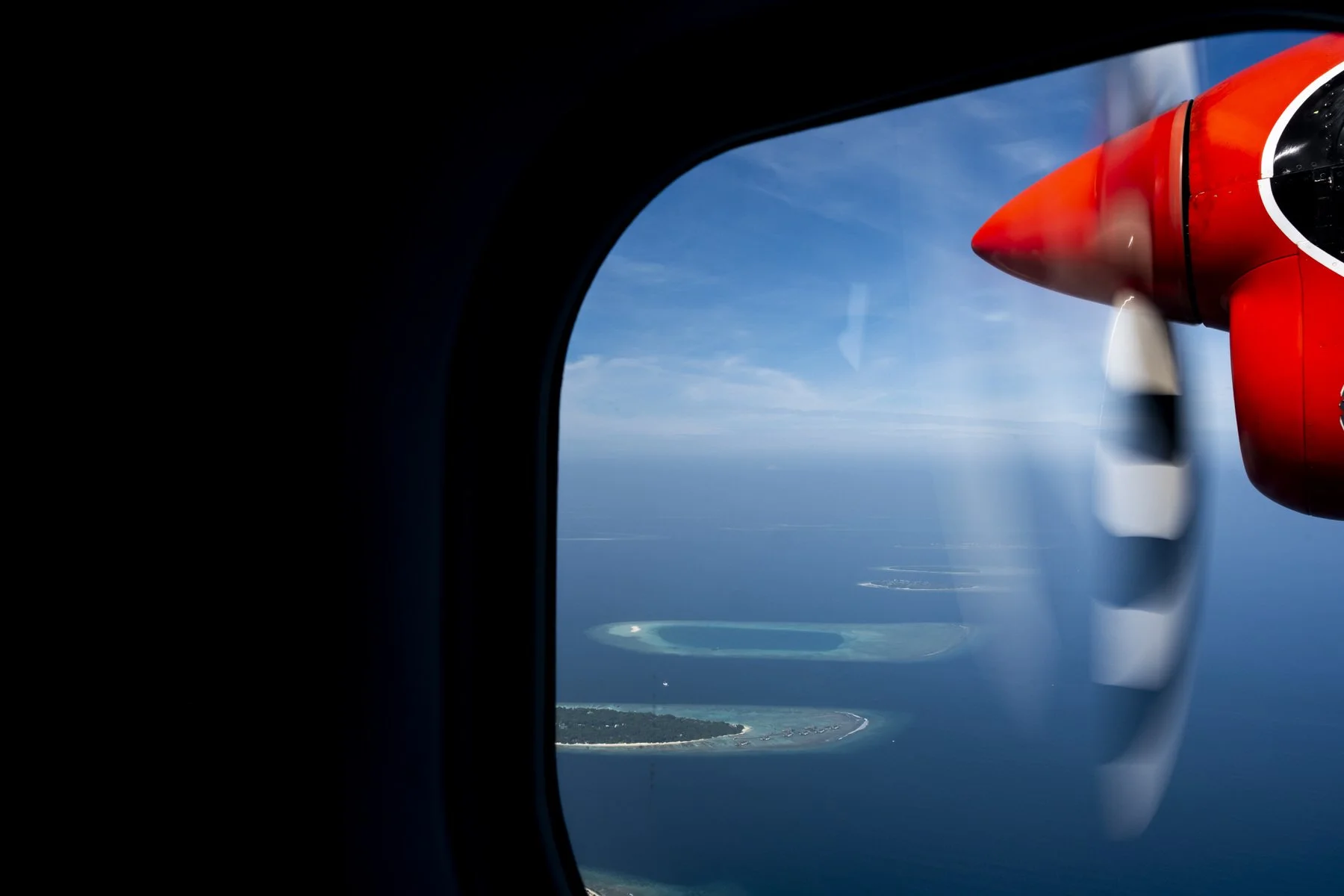 Islands dotted outside of a seaplane window in the Maldives