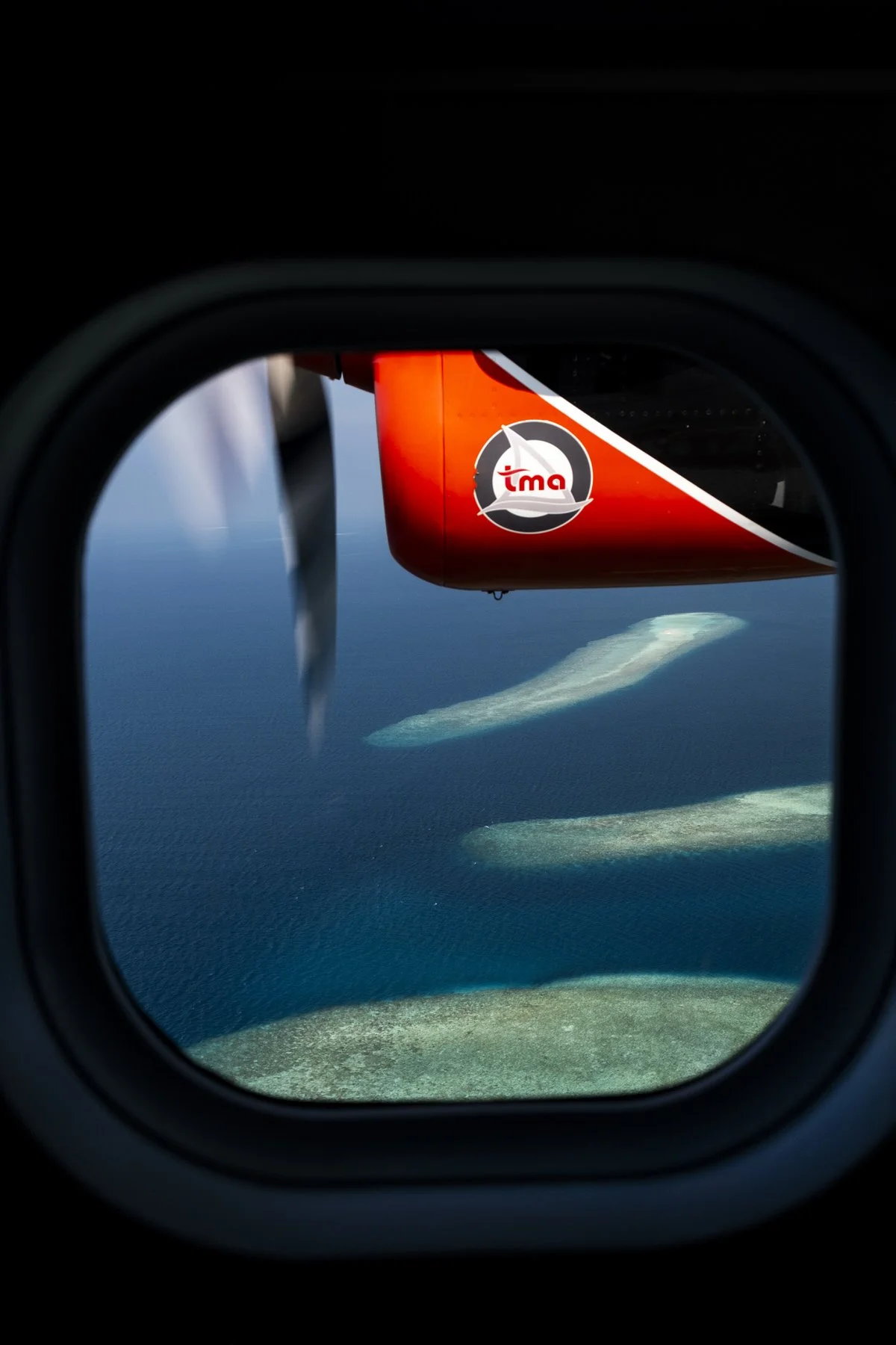 Islands dotted outside of a seaplane window in the Maldives
