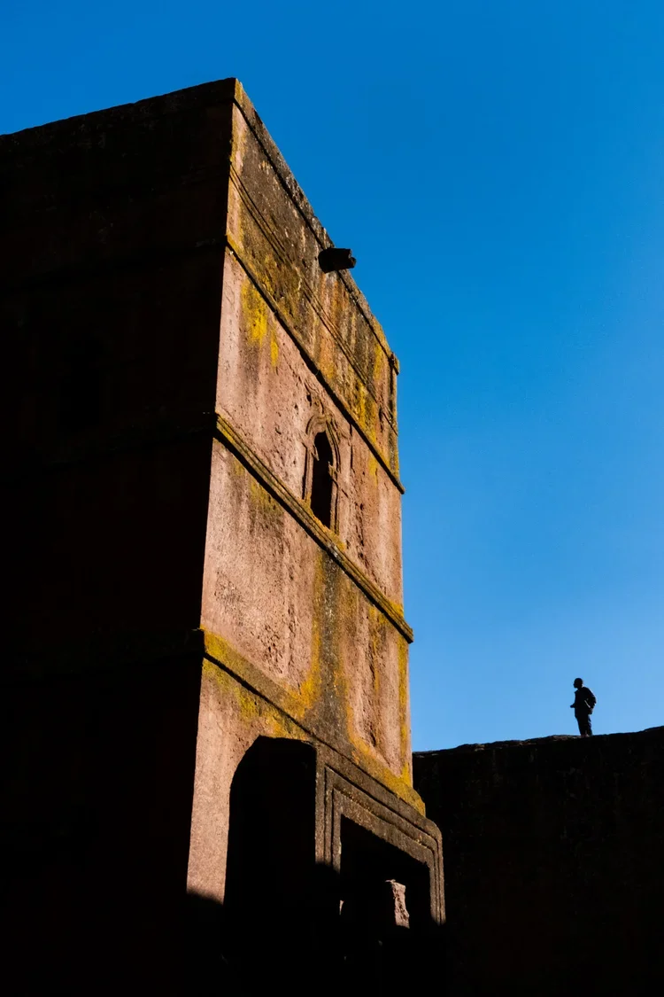 Pilgrim looks at Saint George church in Lalibela, Ethiopia