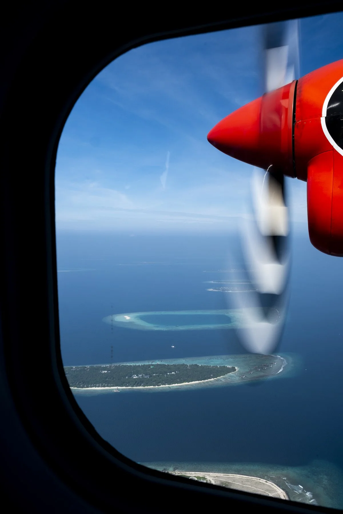 Islands dotted outside of a seaplane window in the Maldives