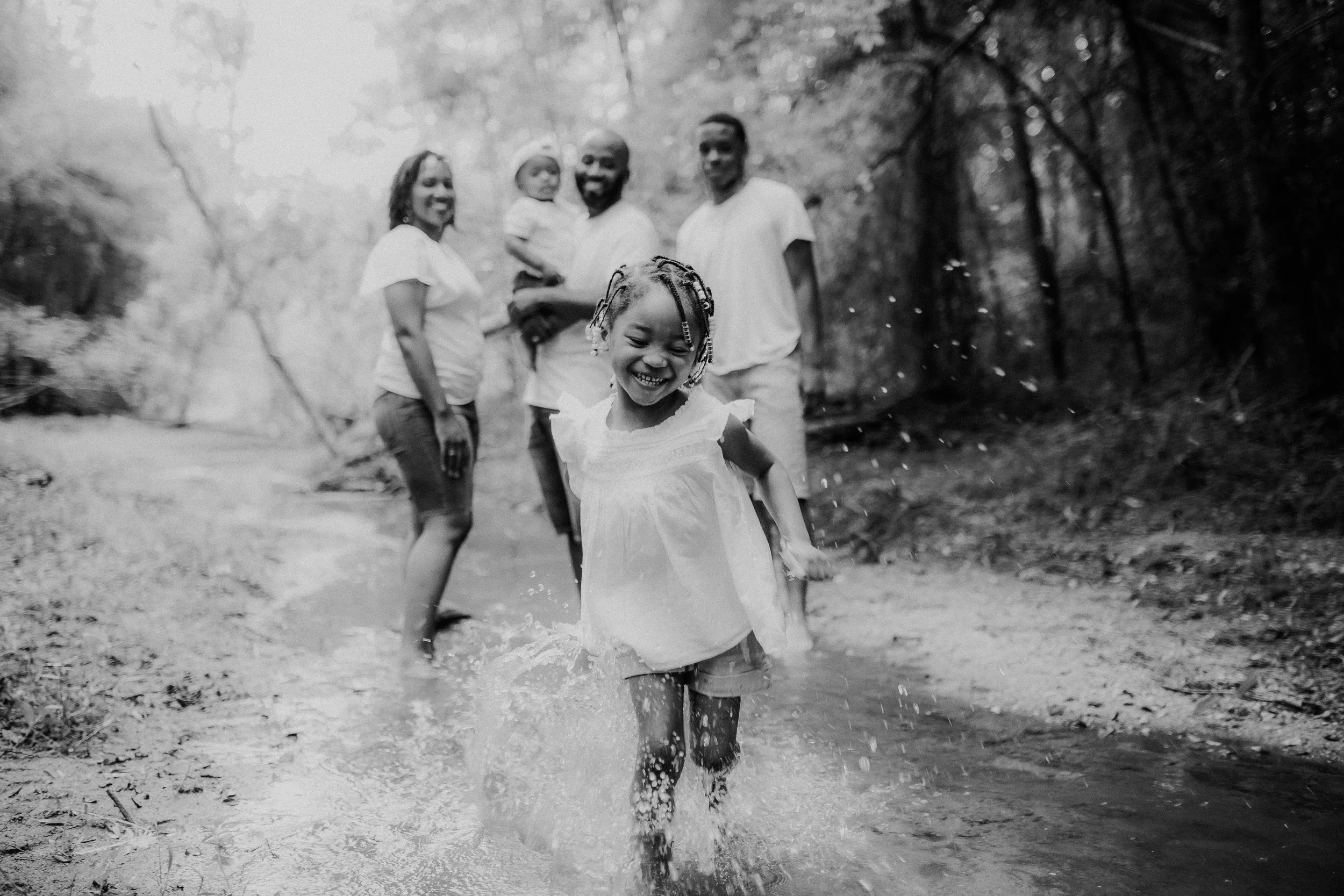 Girl with her family running through the river and splashing water in Rome Georgia