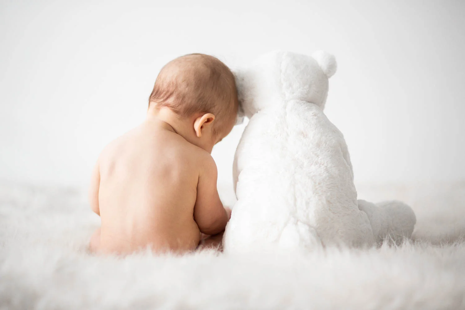 Baby with a white teddy bear