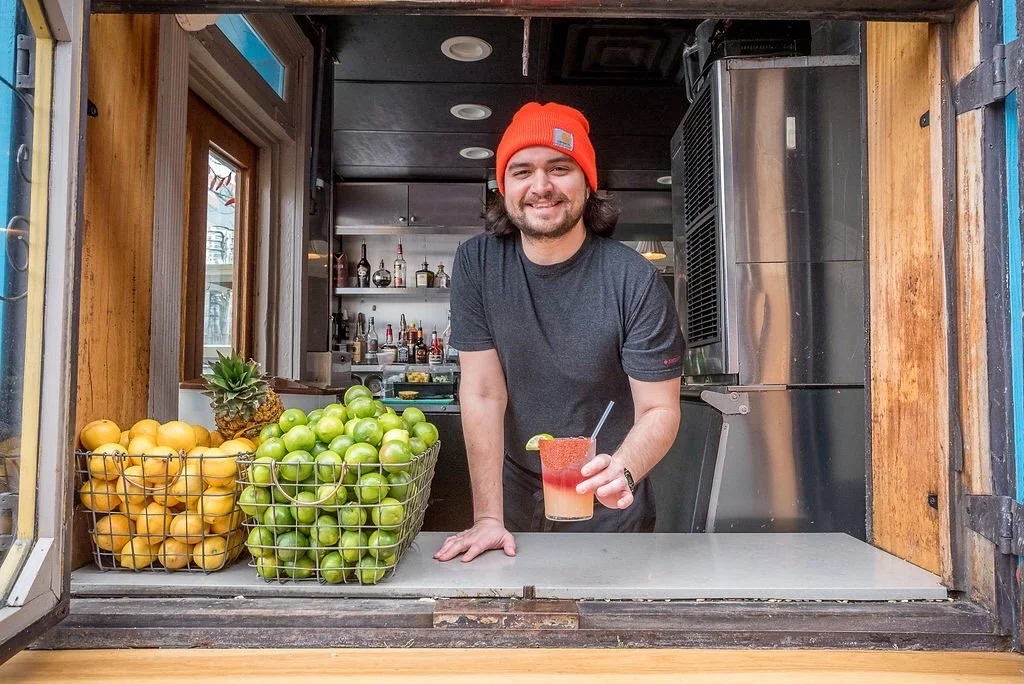 Salsa's team member preparing a fresh juice at the walk-up window of the downtown Asheville restaurant