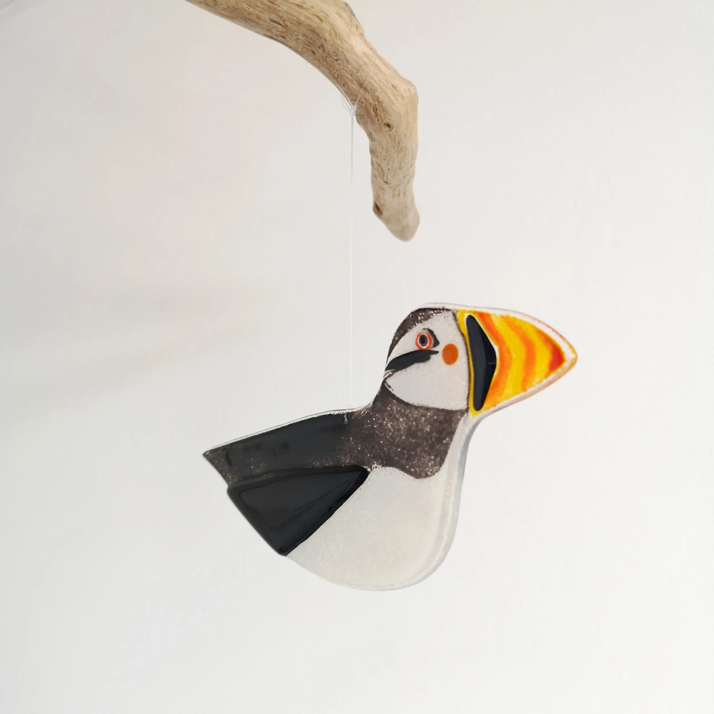 Front view of a glass puffin decoration.