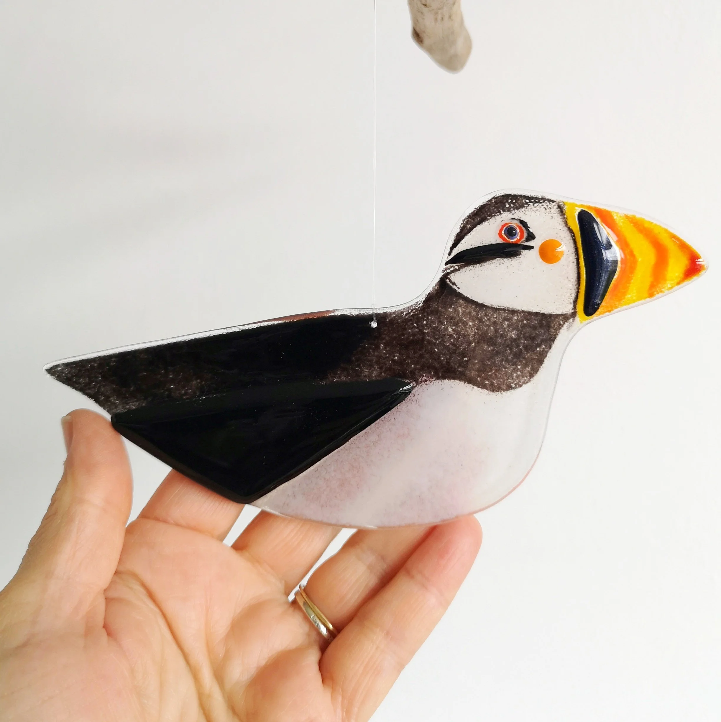 A fused glass puffin decoration.