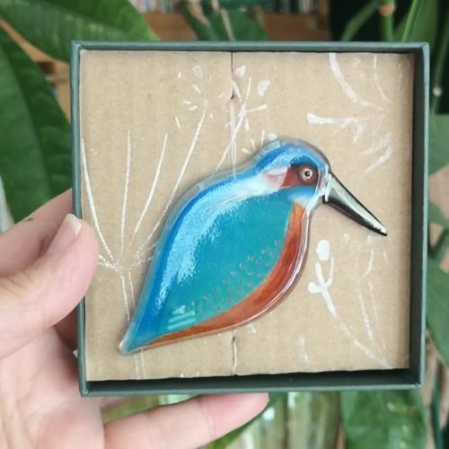 A glass kingfisher decoration in a box.