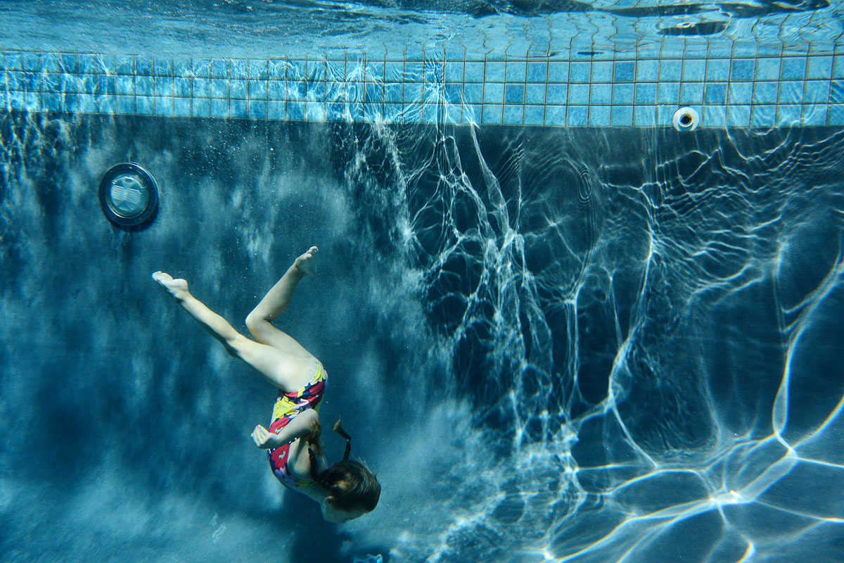young girl swims underwater in New Jersey swimming pool