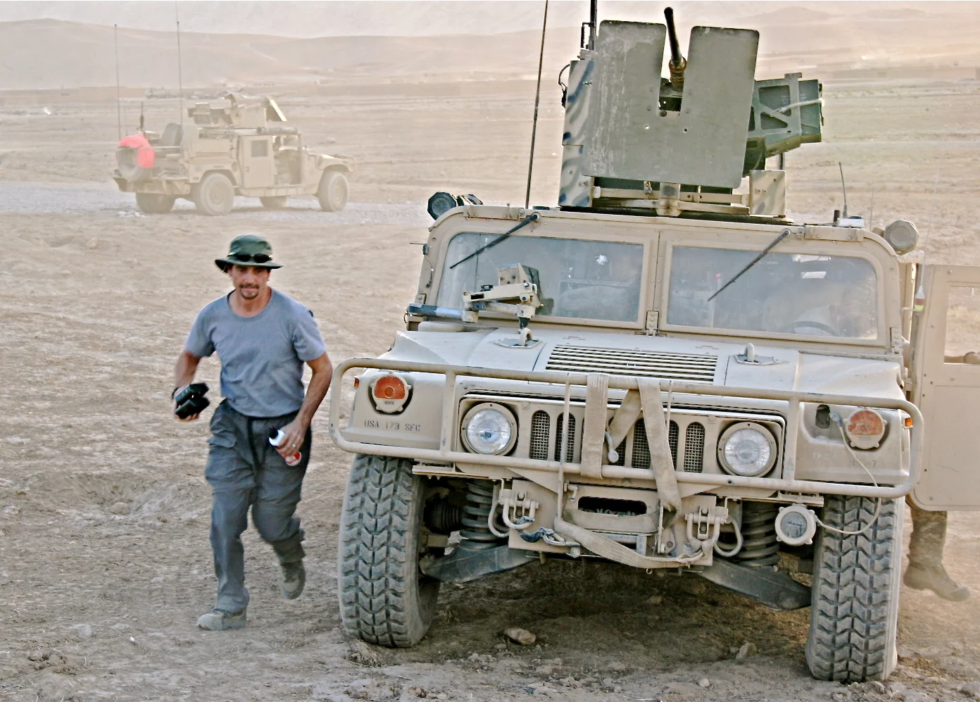Steve Hoggard carries spare batteries from one gun truck to another while filming a combat patrol...