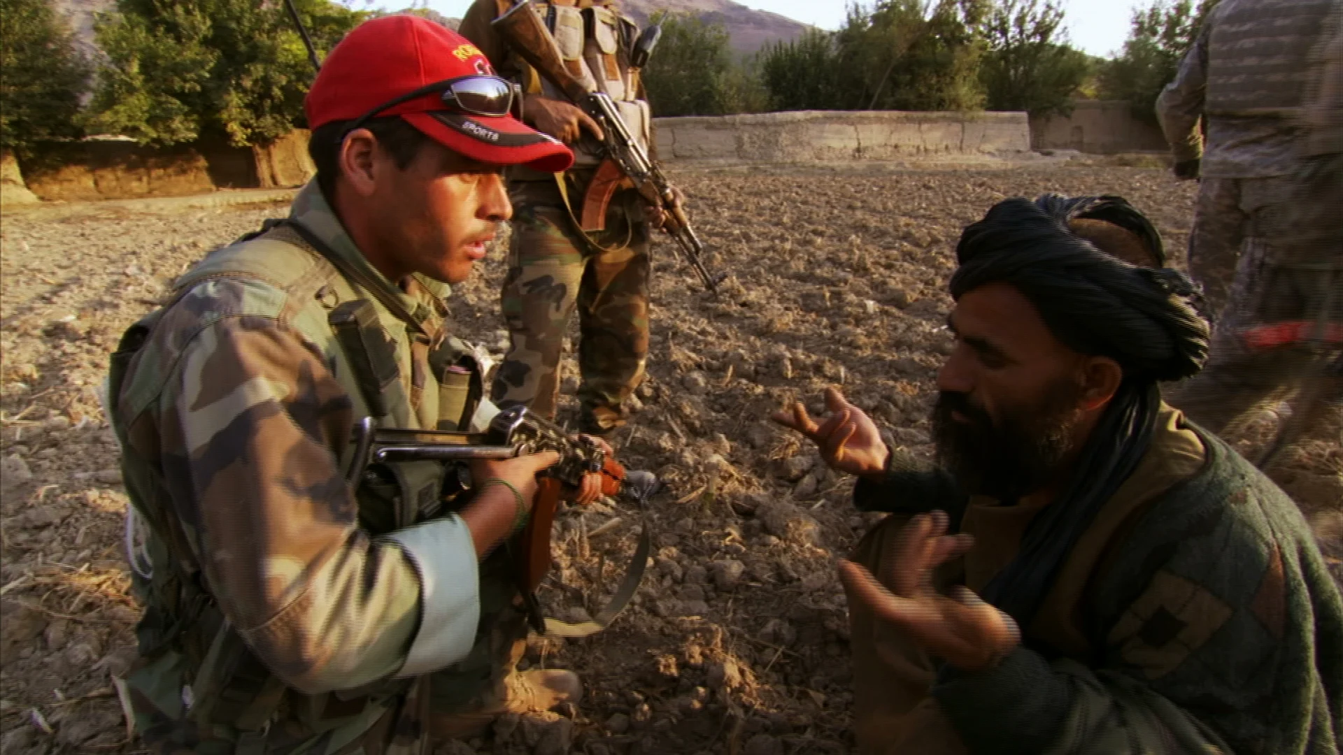 An Afghan National Army soldier interrogates the suspected spotter.