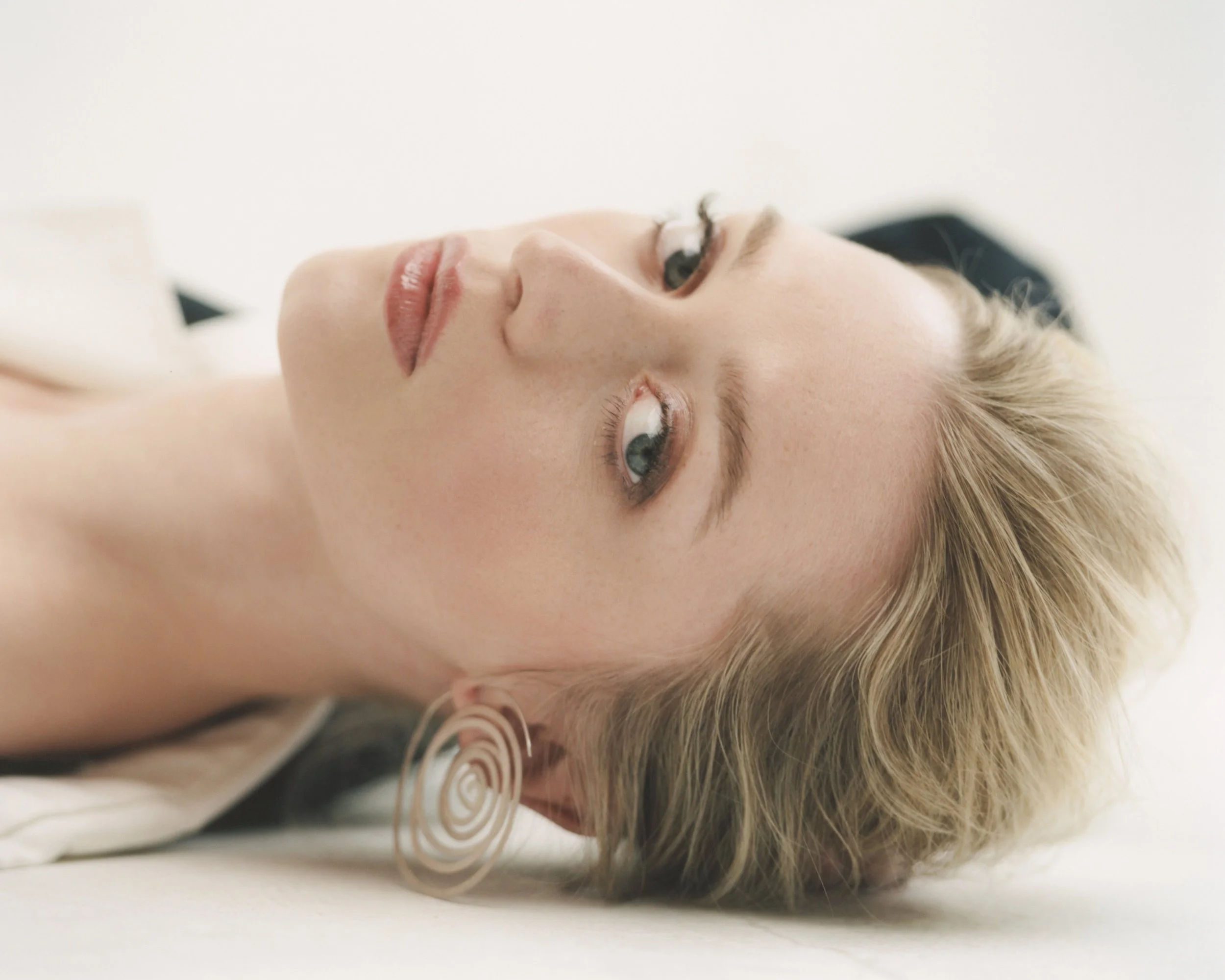 Poet Anna Seidel wearing JAKHU STUDIO Espiral earrings, photographed in soft natural light