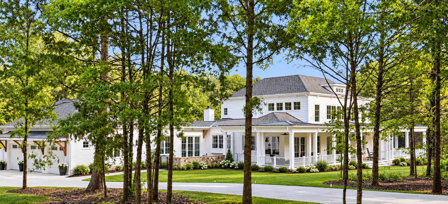Elegant White Farmhouse in a Wooded Setting.png
