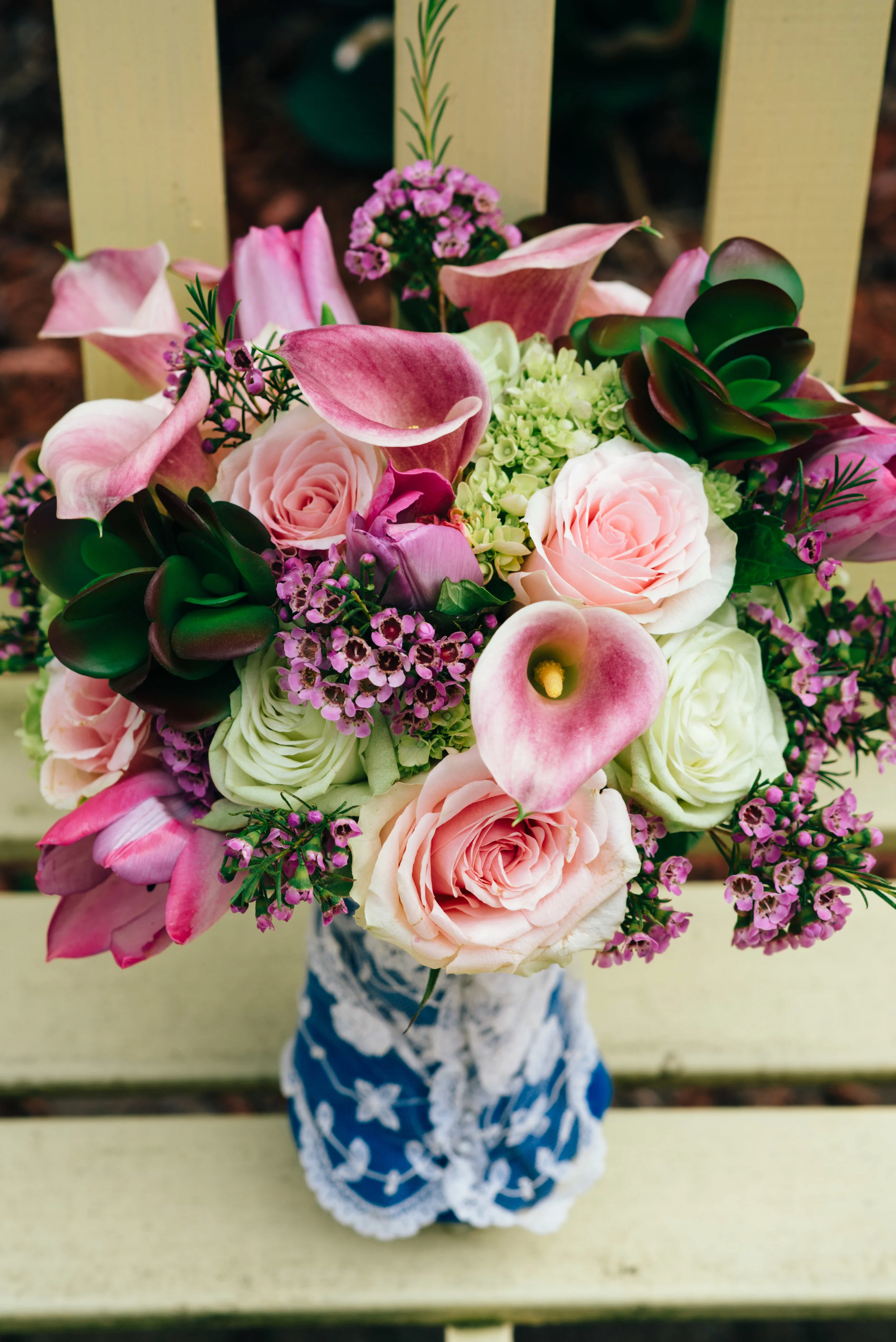 Wedding bouquet by Wedding Elegance by Joelle featuring pink roses, succulents, purple cala lilly's, and purple tulips.