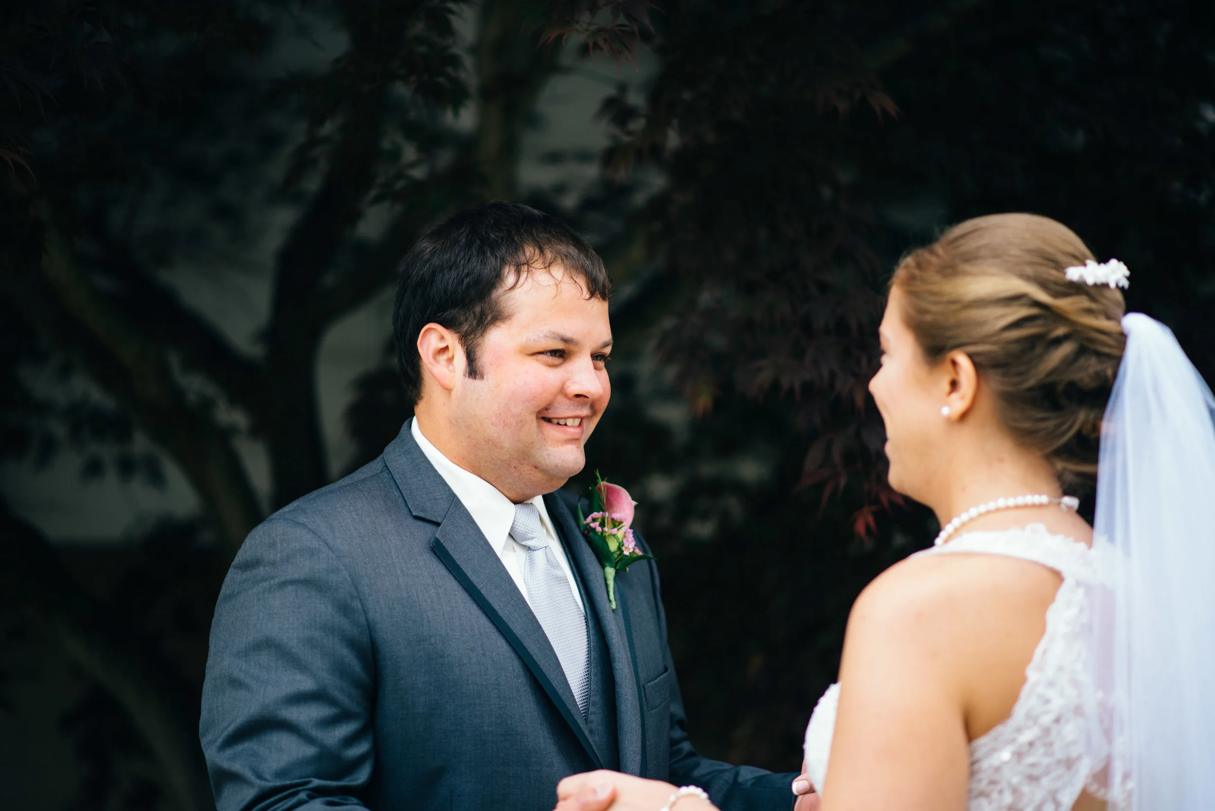 A groom wearing a charcoal suit form Vera Wang's Black collection sees his bride for the first time during their first look.