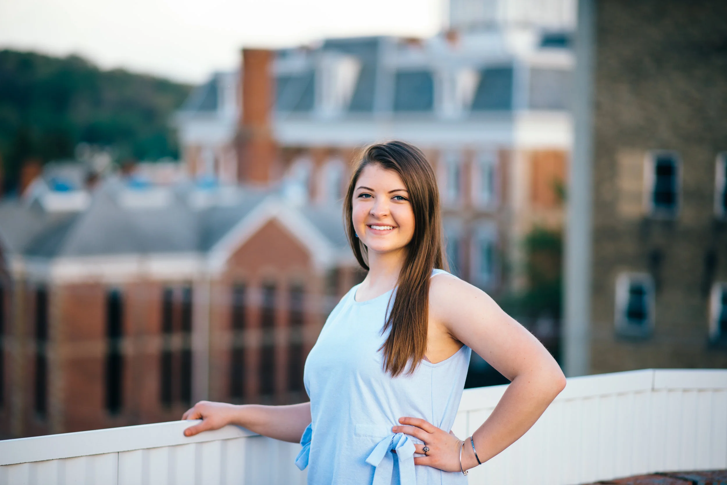 high school senior model in light blue shift dress standing on top of parking garage overlooking city of Indiana PA