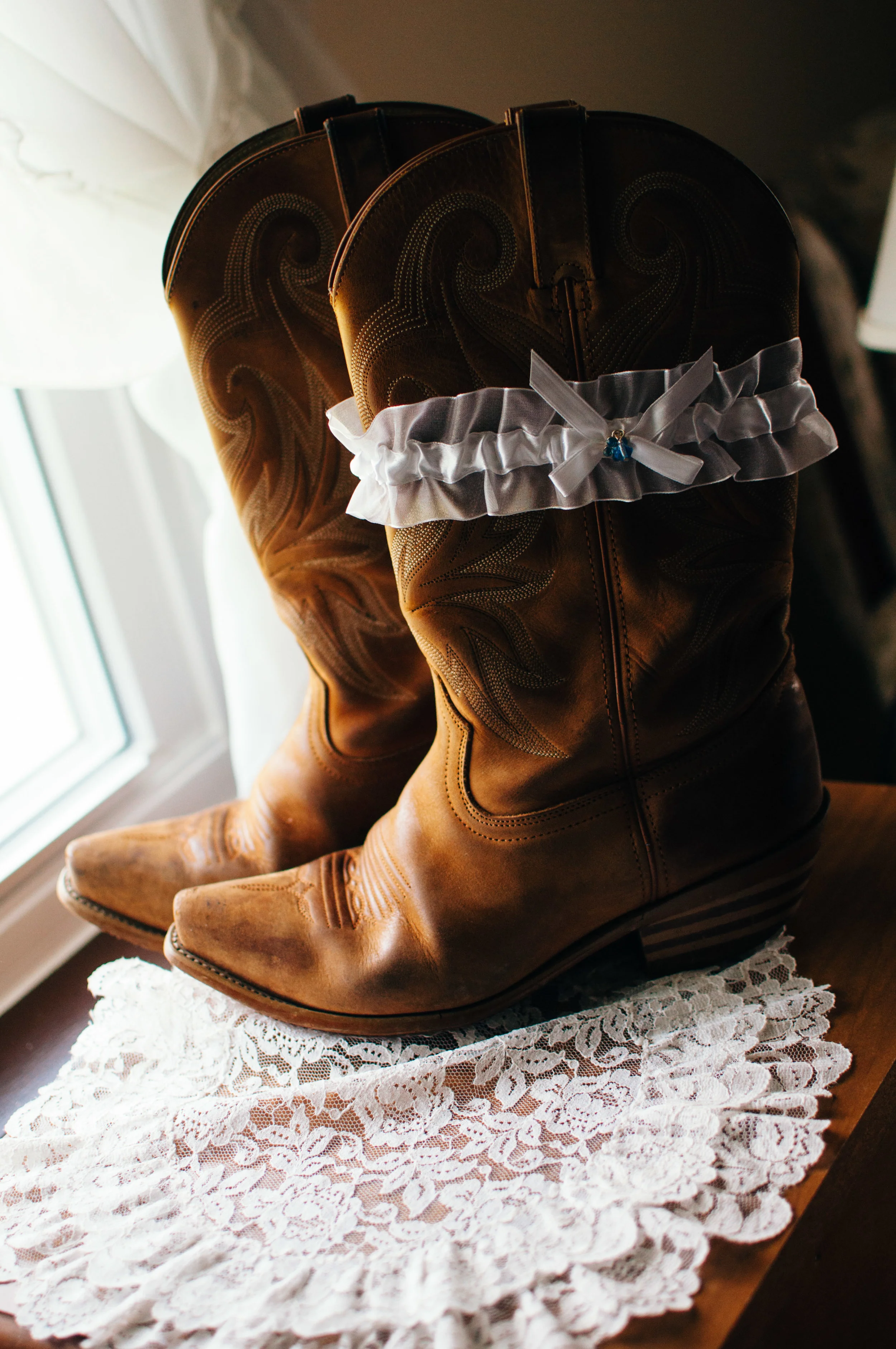 wedding garter with something blue on brides western cowboy boots worn under her wedding dress