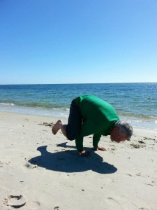 The author's dad, Yogaman Bill, letting go of anxiety and creating beauty on the beach.