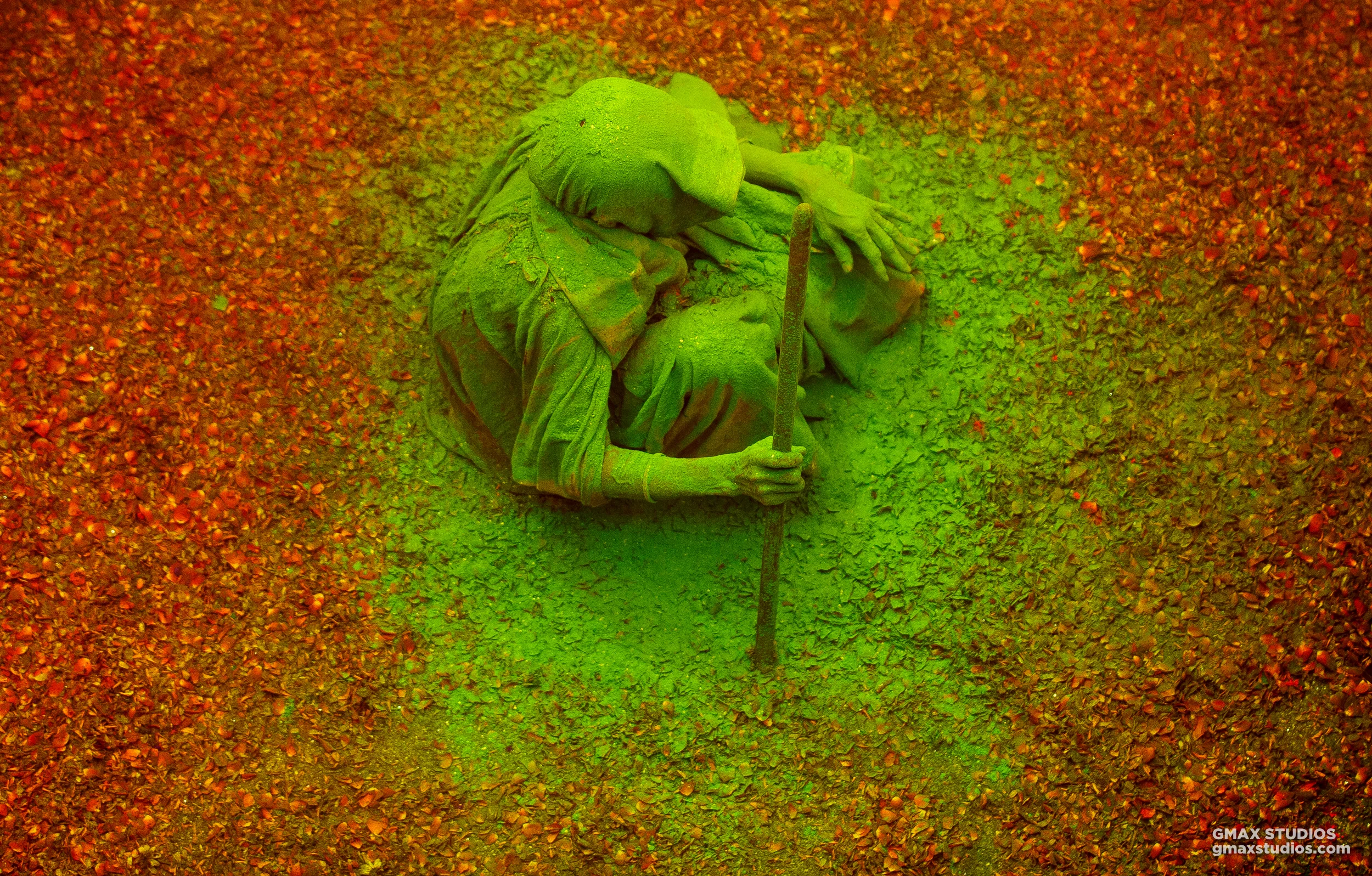 We had gone up an empty staircase to change lenses when we saw the lady in the picture surrounded by flower petals. Moments later, another widow came by and unloaded a bucket of green color on her.