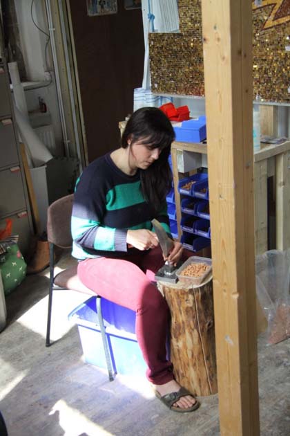 Victoria, an assistant, using a hammer and hardy.