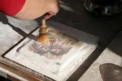 The cloth being applied with hide glue to a study piece