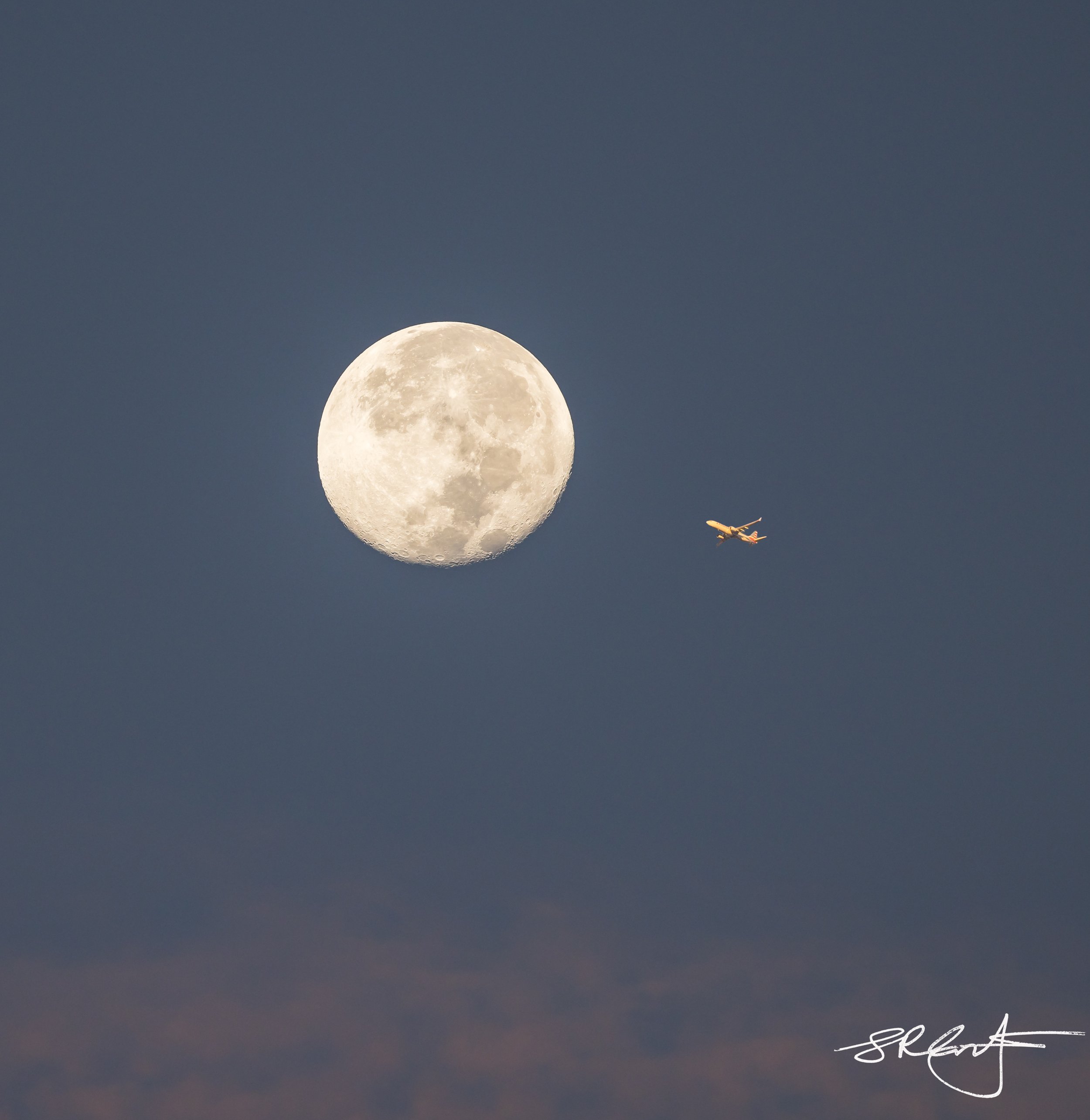 Jet flying past the full moon.
