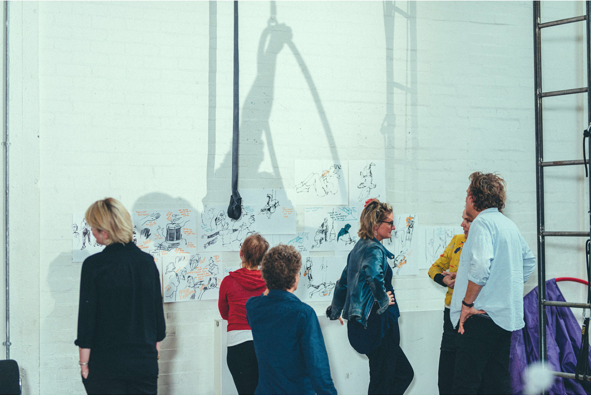 Performers and directors looking at drawings, which we put up around the rehearsal space throughout for reference. Photography by Dom Moore