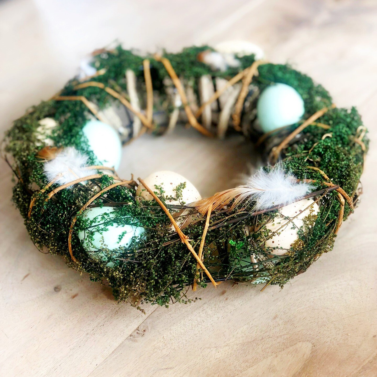 Beautiful wreath created with twigs and moss decorated with pastel eggs and feathers. The wreath will create a show stopping entrance when hung on your front door.