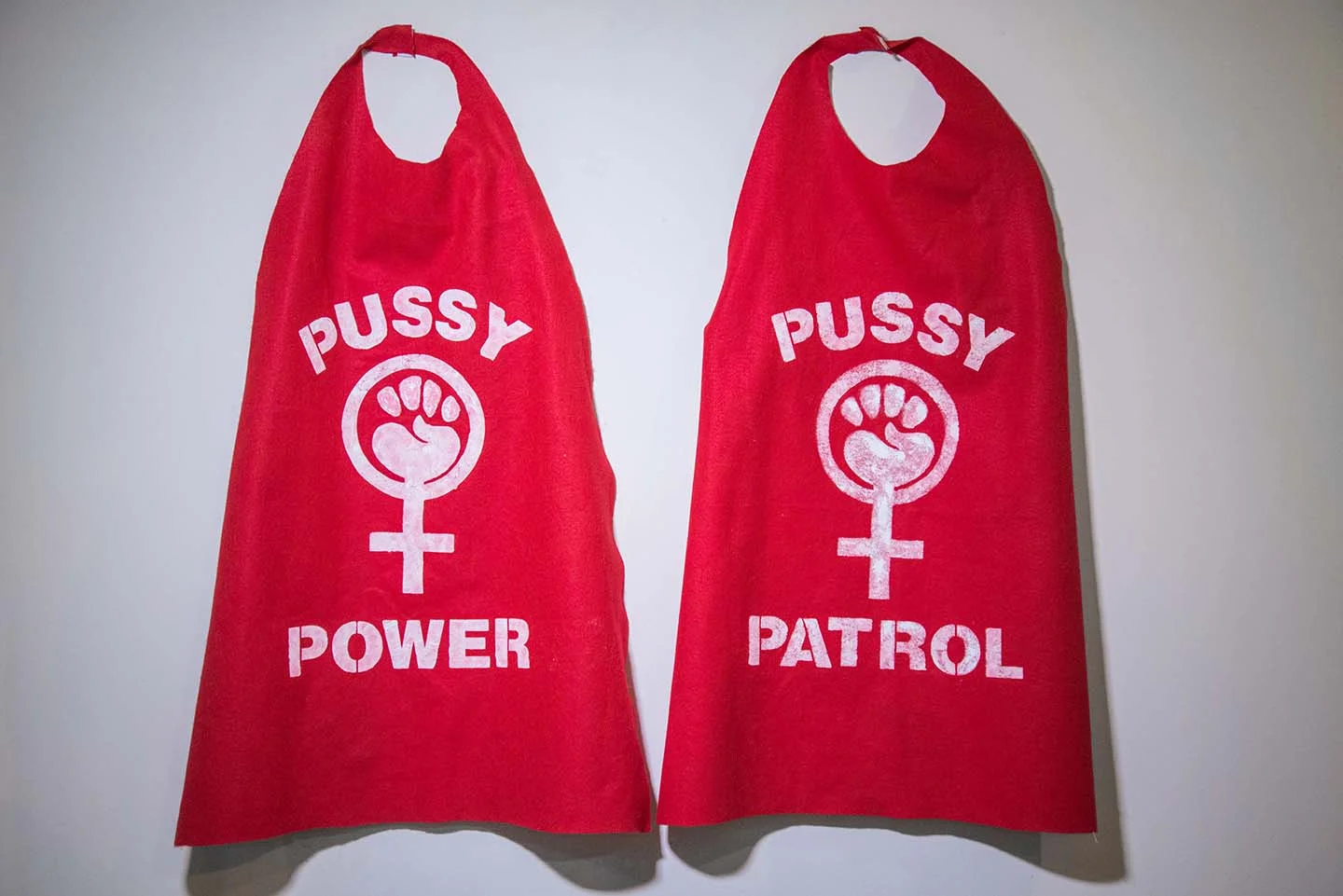 Katy Martinez, Pussy Patriot Capes , red felt, white acrylic paint, velcro, 32"x43", DC March 