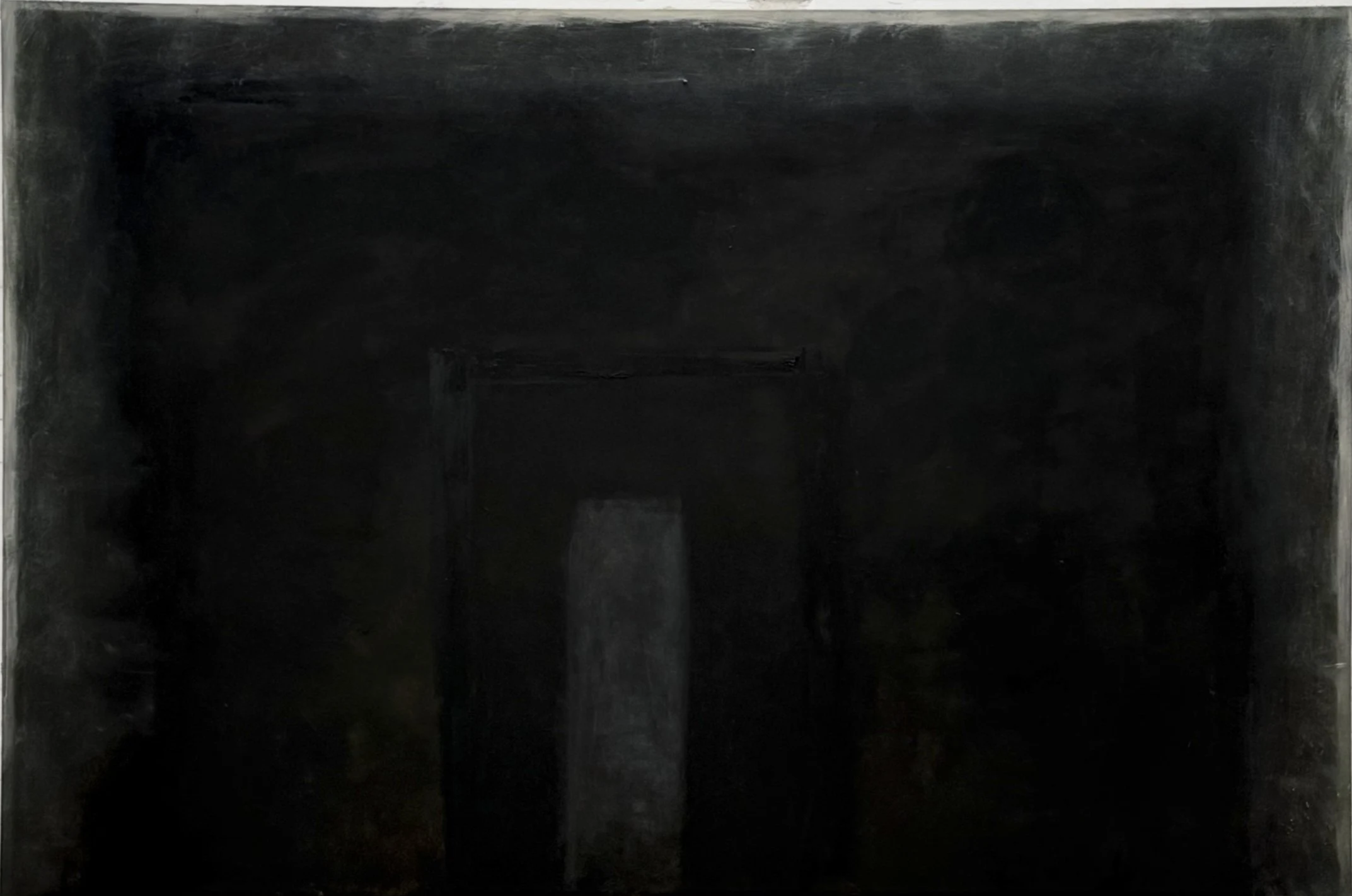 A dark, empty, indoor space with black painted walls and ceiling, resembling a basement or cellar.