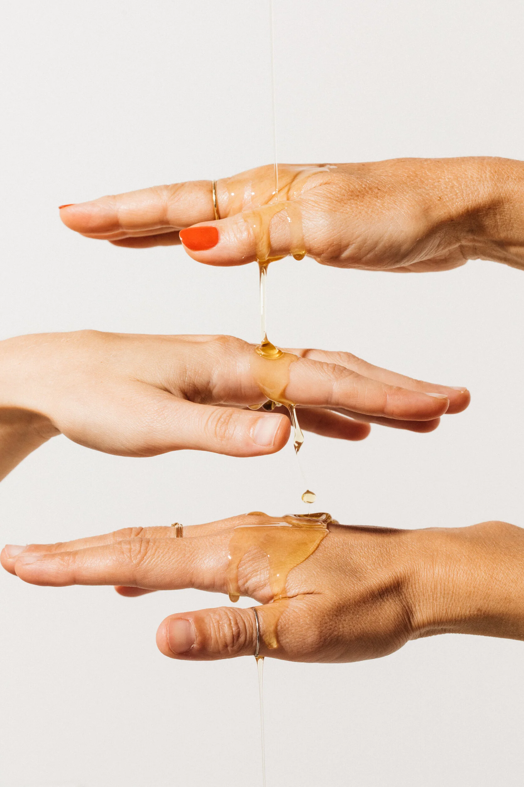 Moringa oil dripping on hands, vibrant healthy skin