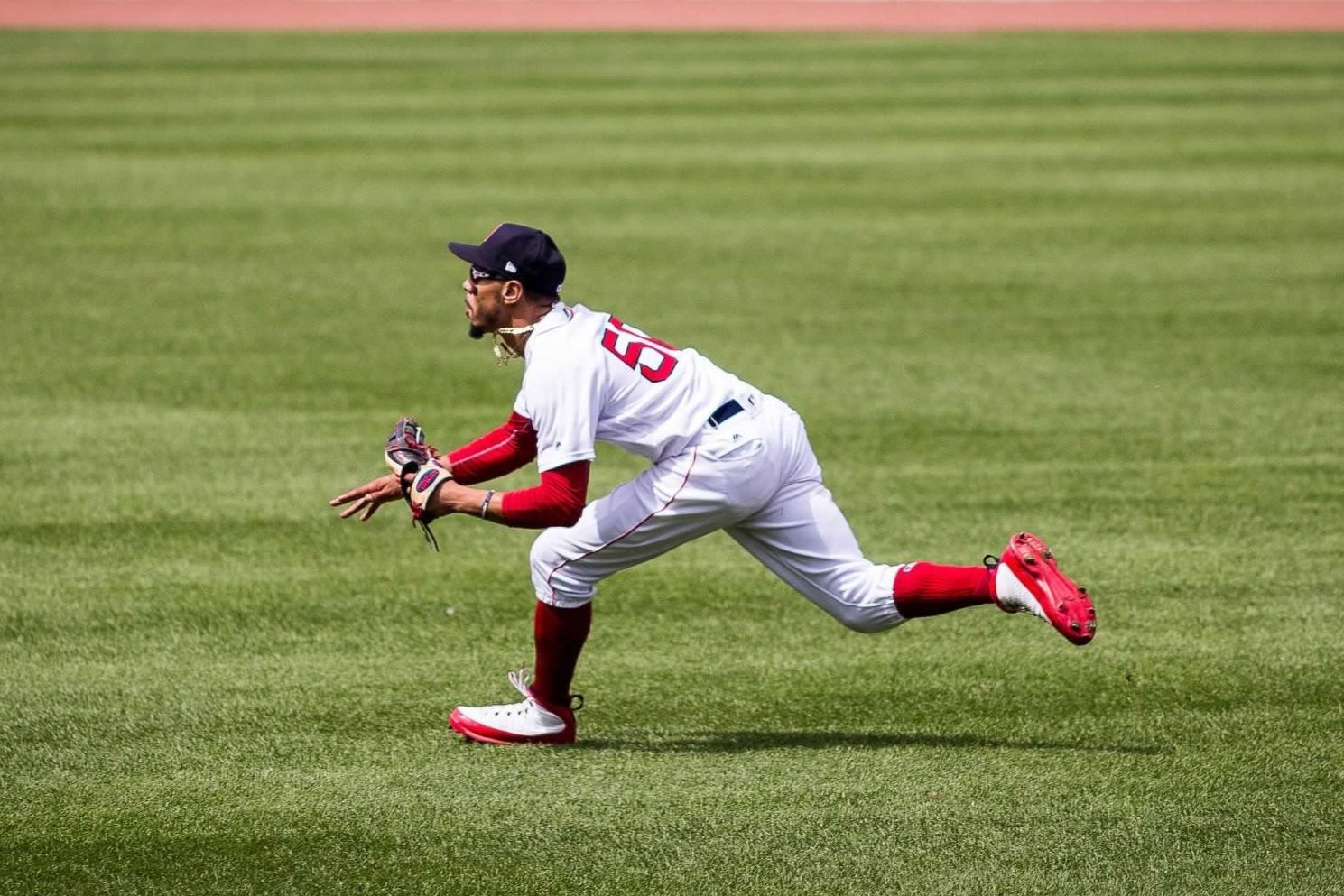 Former Red Sox RF Mookie Betts starts a diving catch, Boston, August 2018.