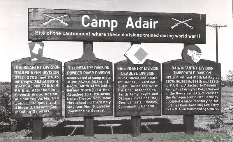 Large signs reads, "Camp Adair, site of the cantonment where these divisions trained during World War II." They include the 70th, 91st, 96th, and 104th Infantry Divisions.