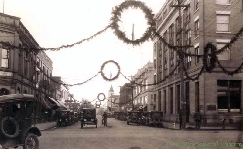 Broadalbin and First Ave at Christmas, showing First National Bank Building, Dentist Dr. Mitchell, and First Christian Church down on 4th and Broadalbin. c. 1934-1938