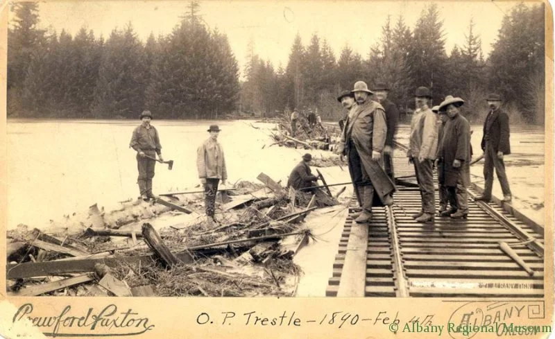 Photo of Willamette River flood dated February 4, 1890, damaged railroad track with several unknown men including Chinese workmen in coolie hats.