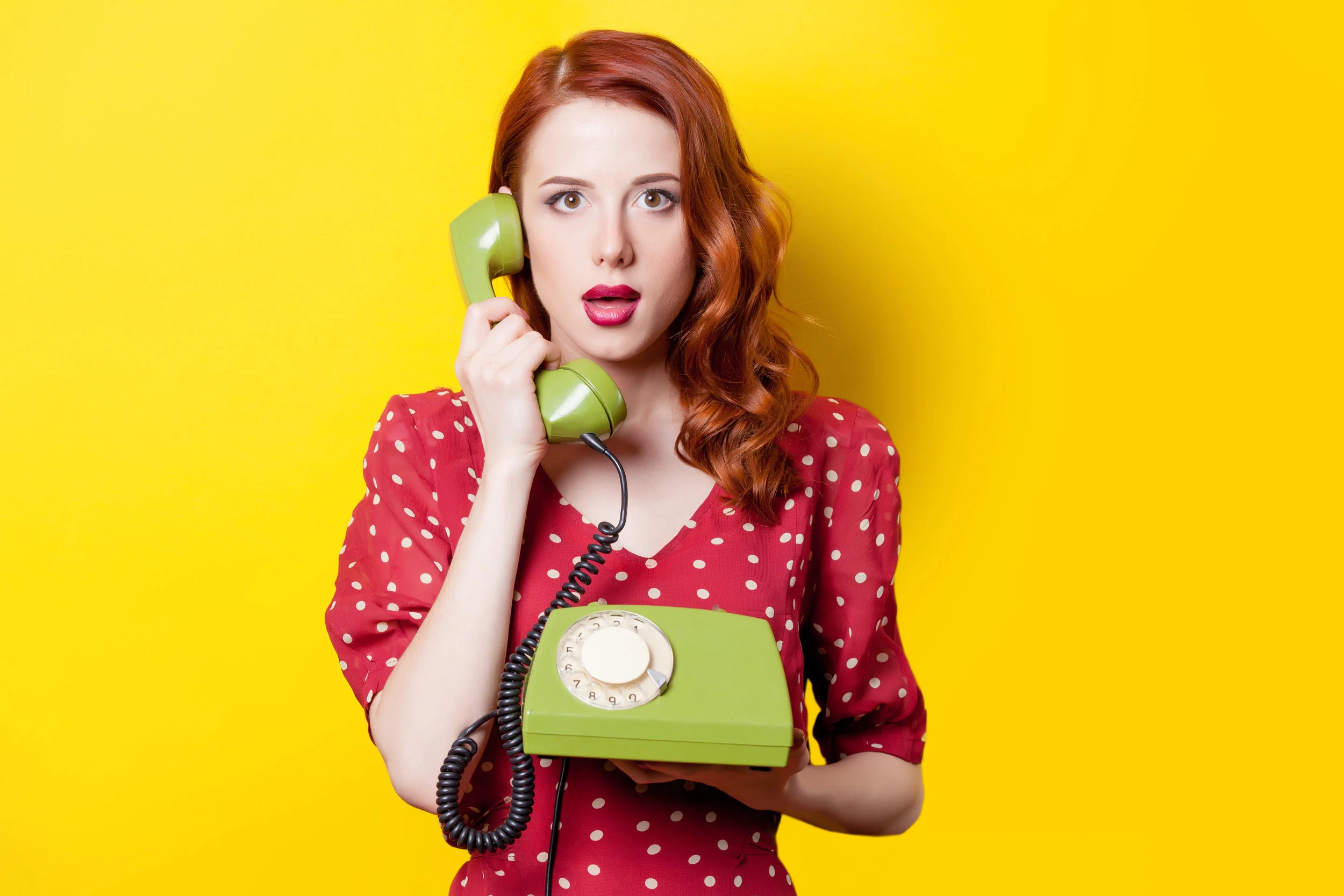girl in red dress with green dial phone