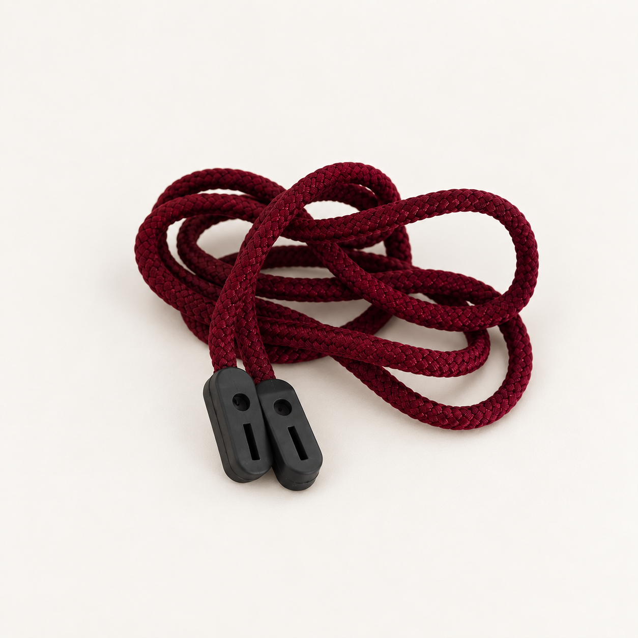 Maroon braided glasses cord in loose loops with two black rubber grip ends