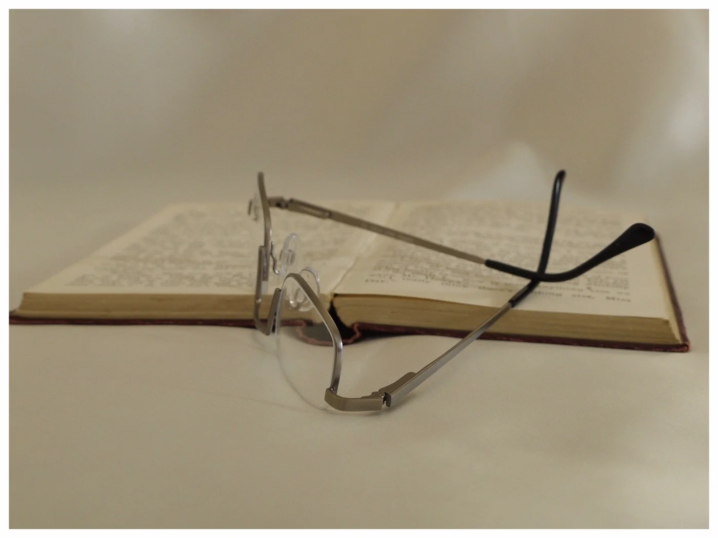 half-eye spectacles in pewter colour, on an old opened book