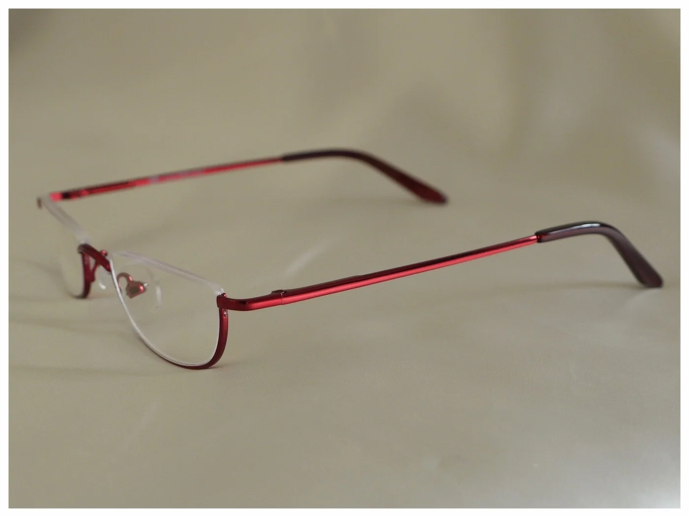pair of red reading glasses in metal half-rim frames