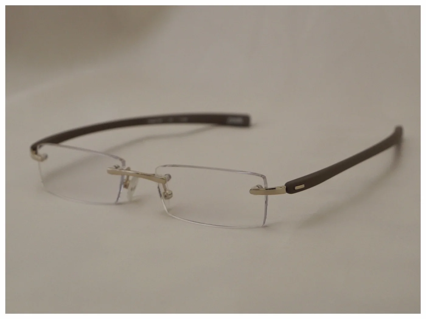 rimless reading glasses with light-gold nose-bridge and hinges