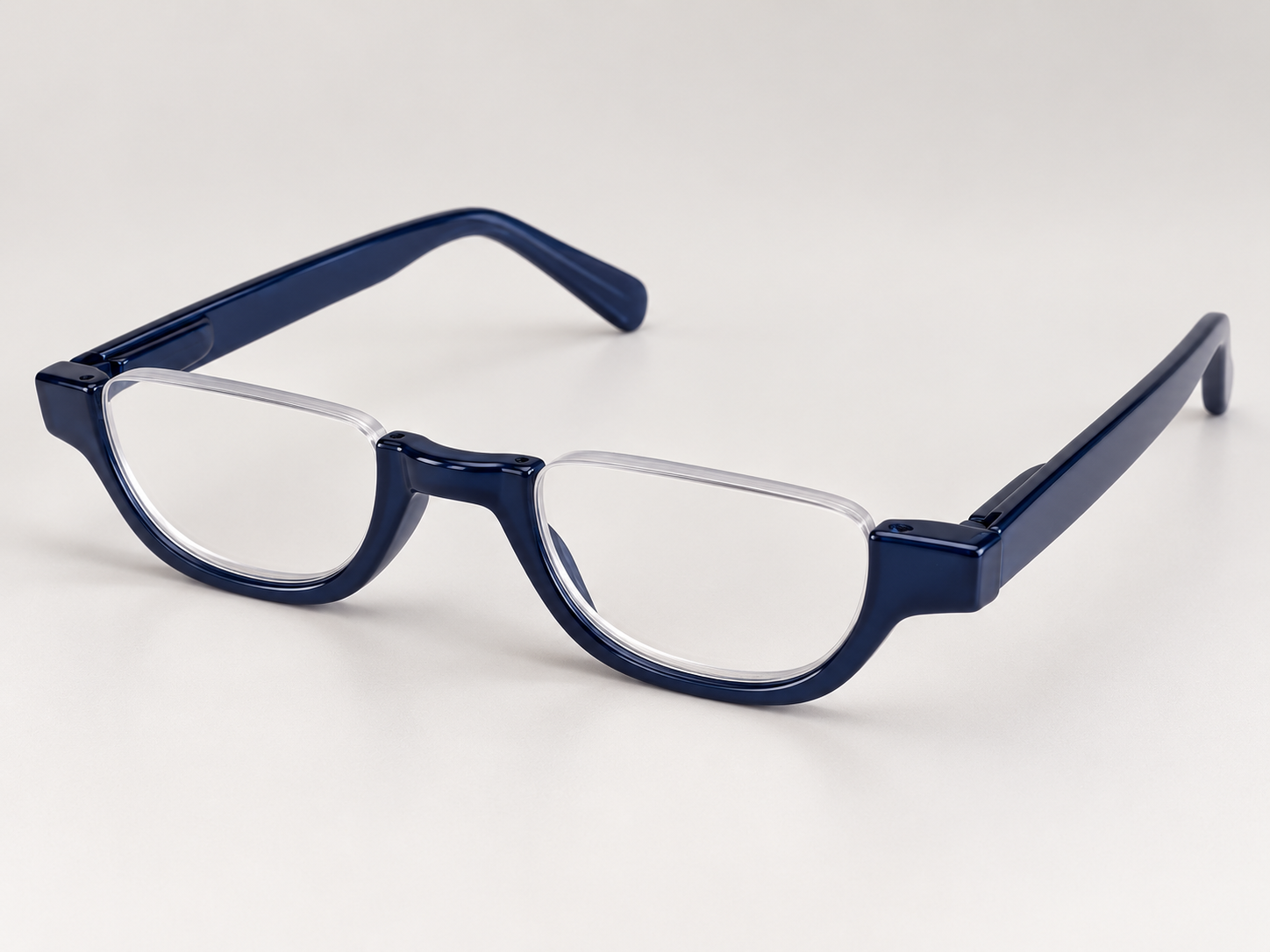 Cove blue half-eye reading glasses viewed at an angle, showing the open-top lenses and glossy navy blue arms