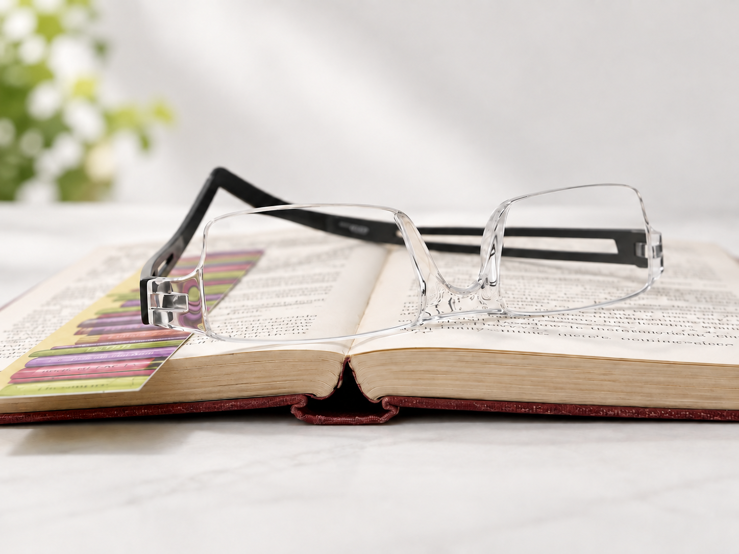 Joy Black reading glasses resting on an open book