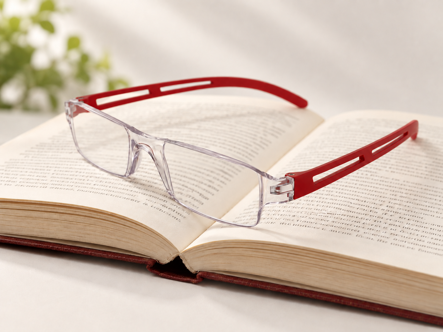 Joy Red reading glasses resting on an open book