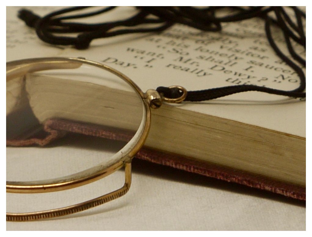Macro shot showing the small loop where the black cord attaches to the vintage gilt monocle frame.