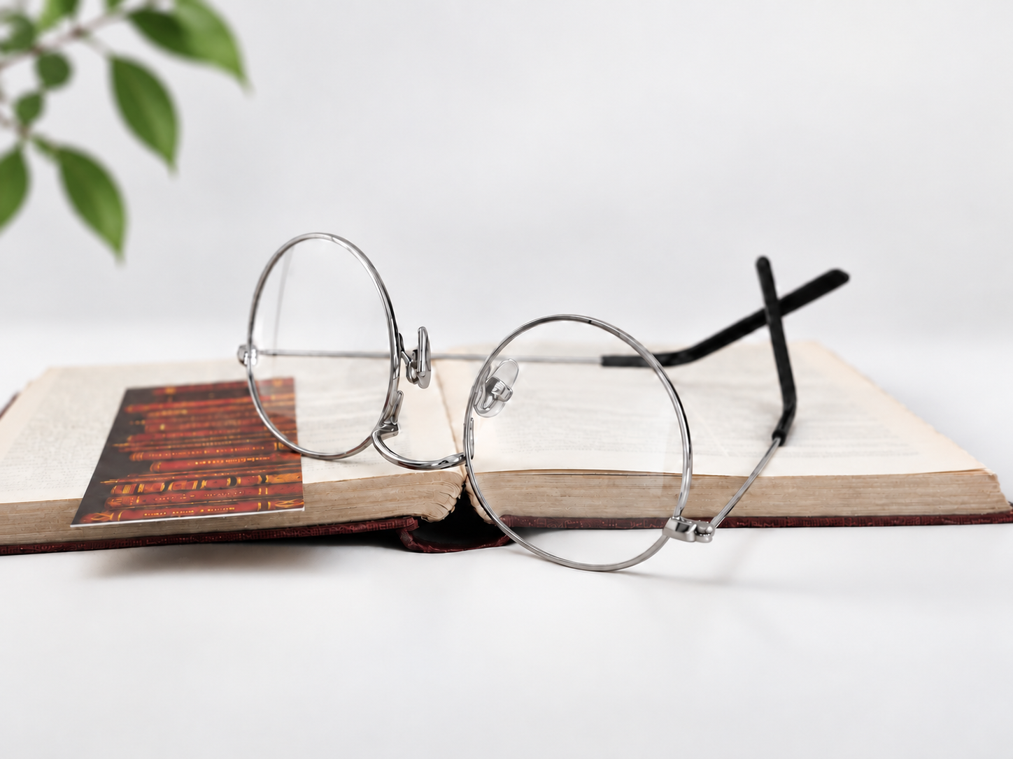 B-376 silver round reading glasses beside an open book