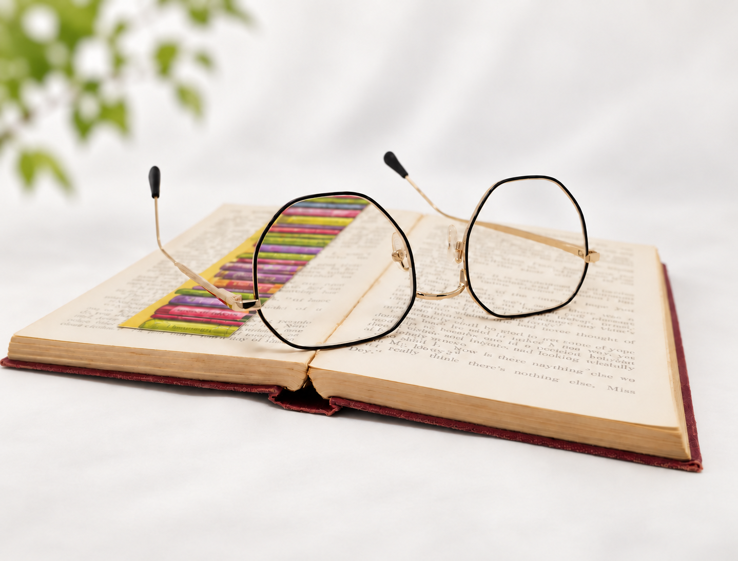 Yoko black and gold reading glasses resting on an open book