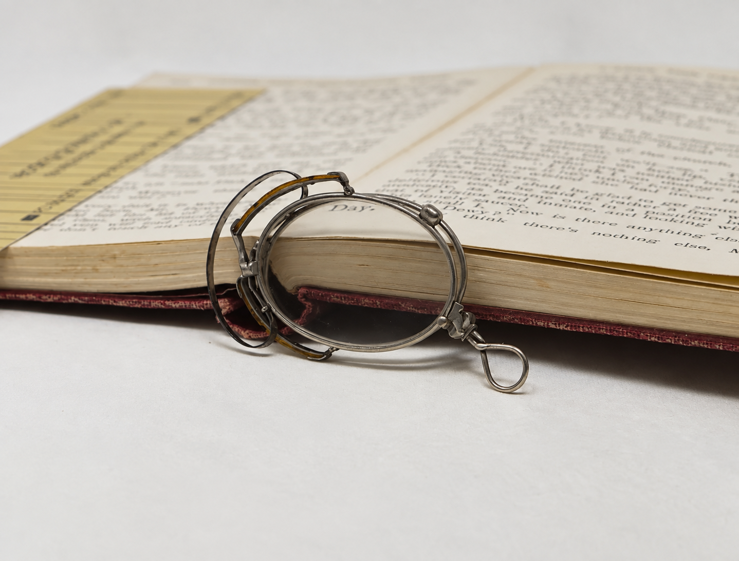 Angled view of antique folding pince-nez showing the sprung bridge, nose pads and lens rims