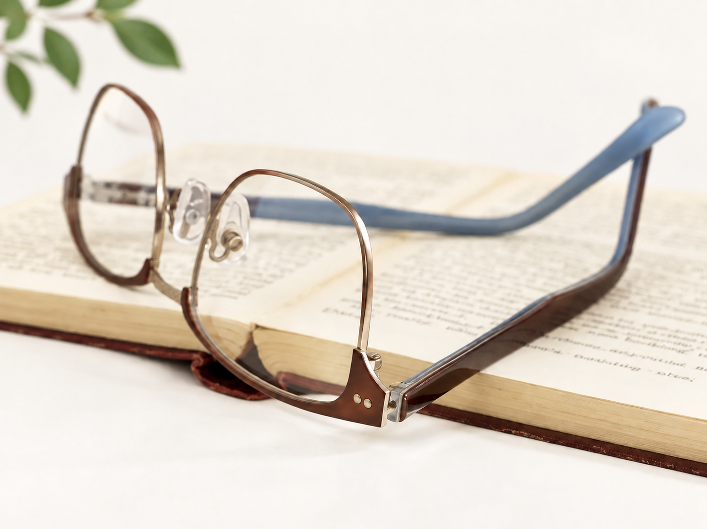 Jacob Stone Rio-501 brown and blue reading glasses beside a vintage book