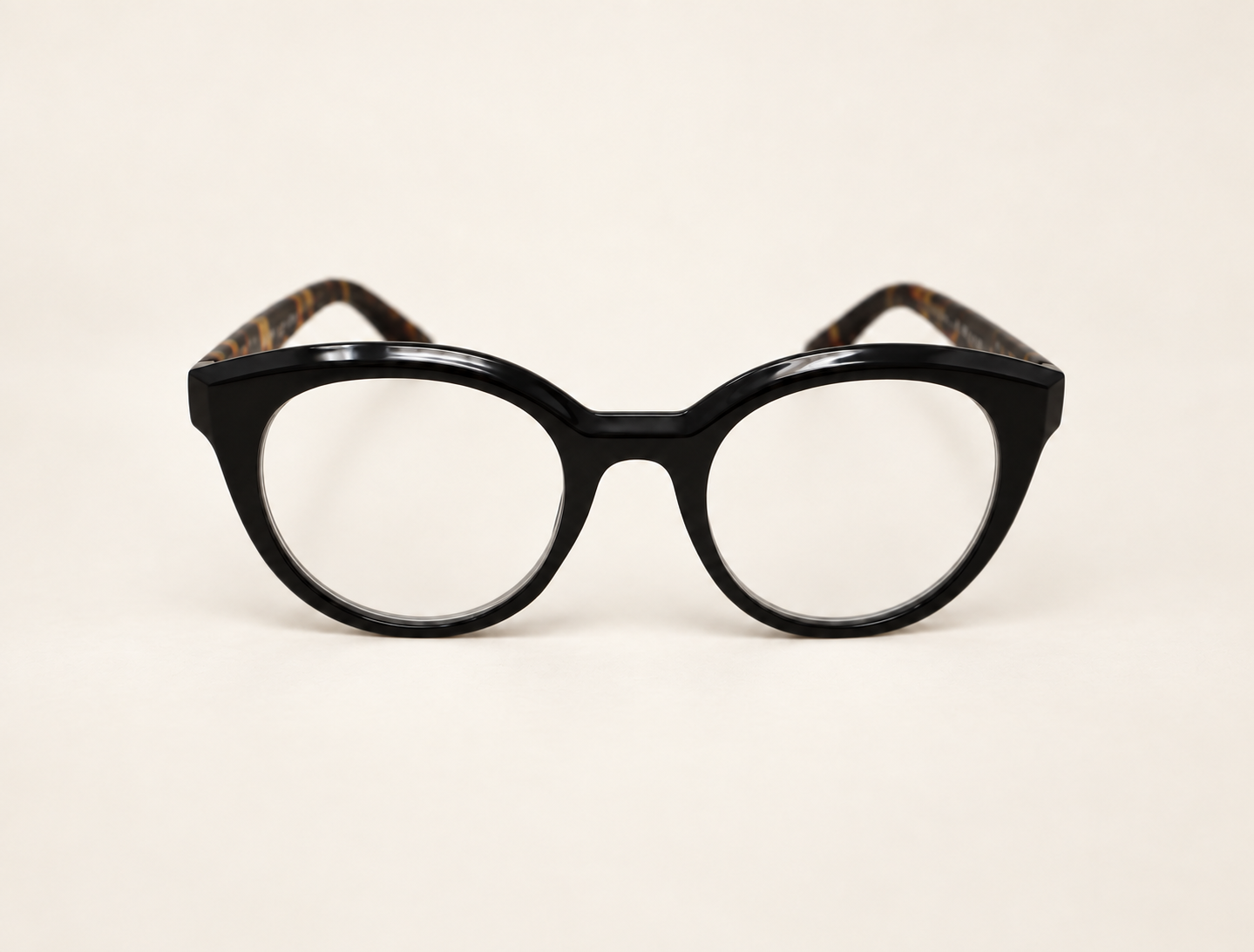 Jackie round reading glasses with a glossy black front and tortoiseshell arms