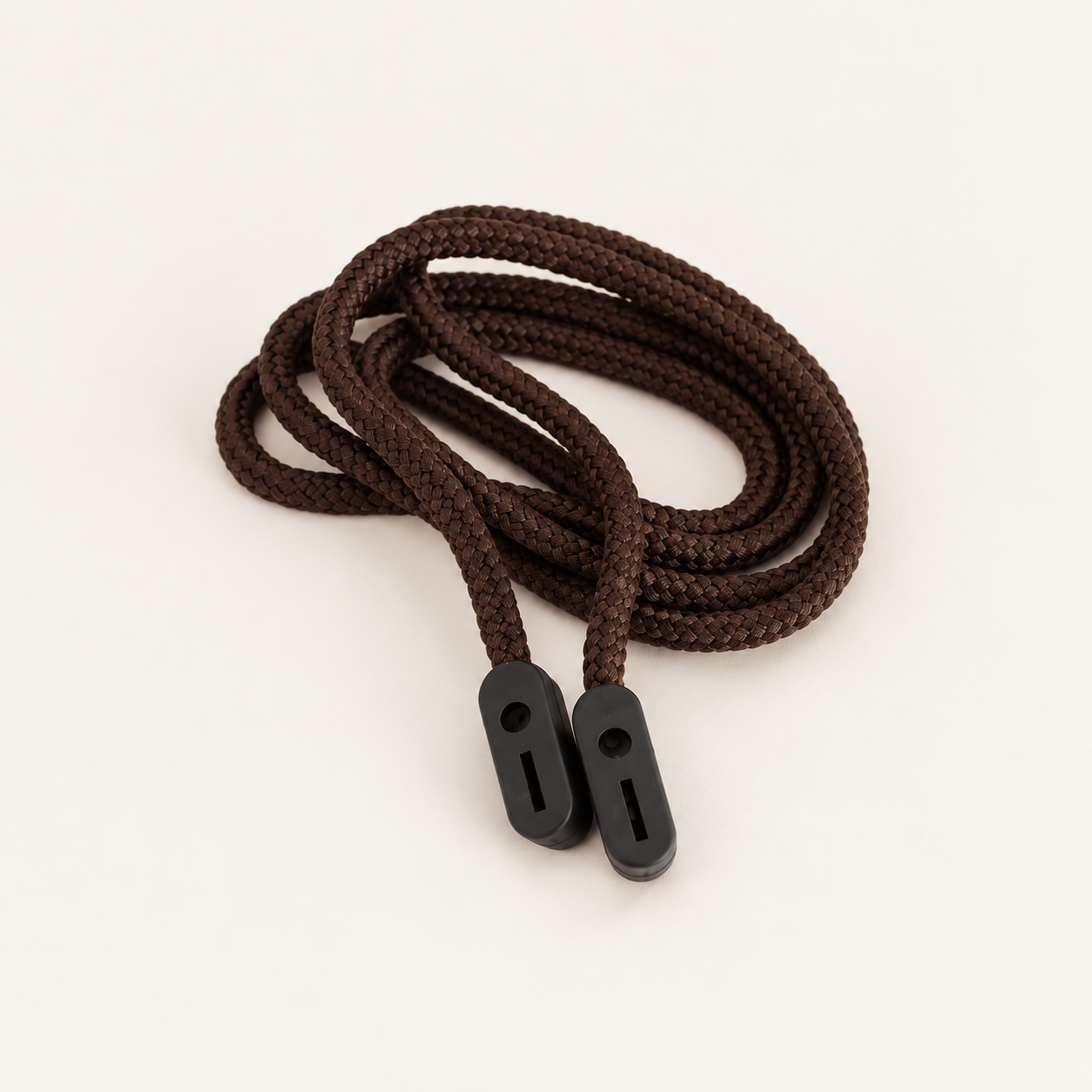 Brown braided glasses cord in an oval coil with two black rubber grip ends