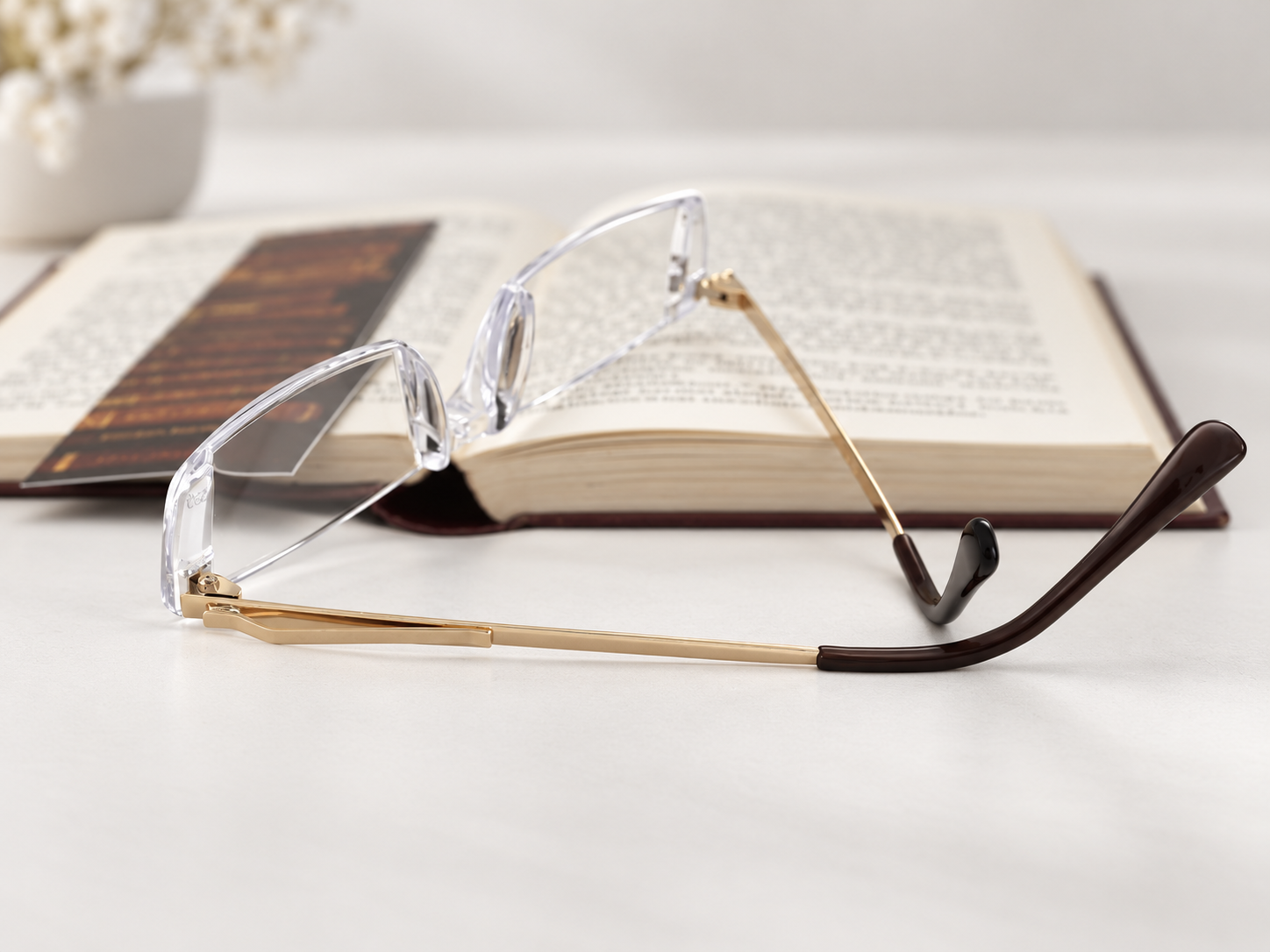 C2200 rimless reading glasses with pocket clip beside an open book