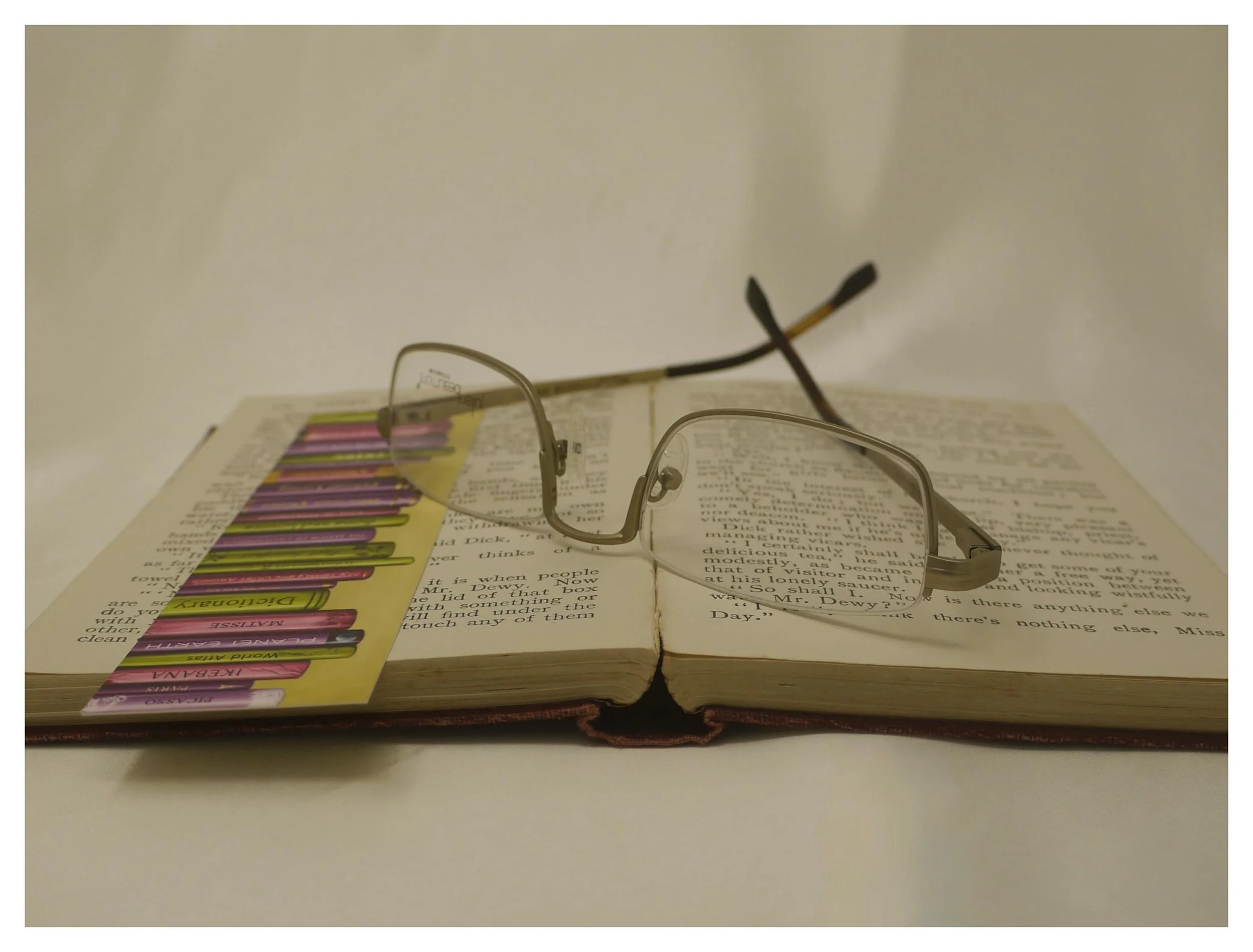 Inverted view of Julian Beaumont 3659 gold titanium half-eye reading glasses on an open book